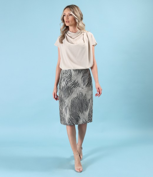 Elegant outfit with flared brocade skirt and blouse with pleats on the shoulder